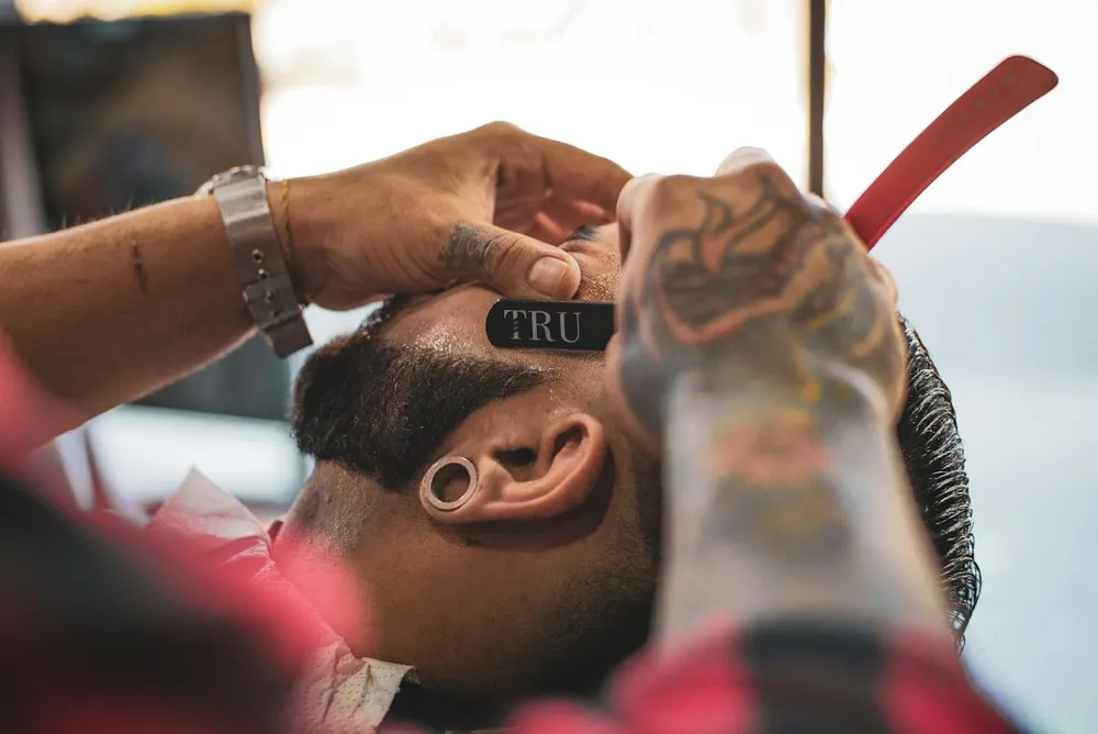 Barber lining up a client's beard